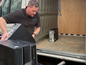 decomissioning - Gigacycle Man loading desktop computer towers into a van at a loading area
