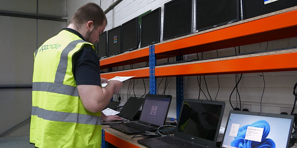 Two colleagues reviewing an IT asset recovery report with device-level data