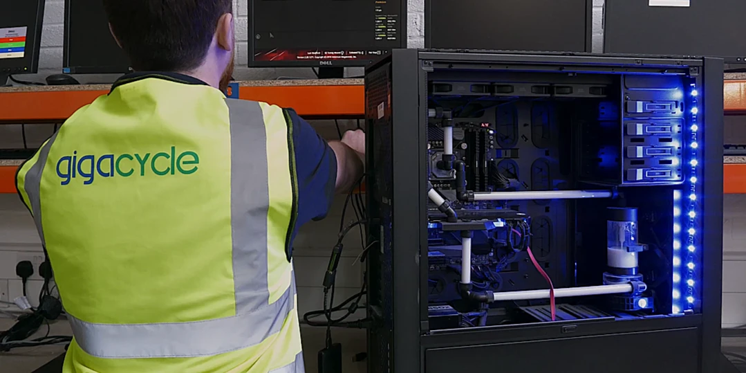 Technician removing reusable components from old computers for parts recovery