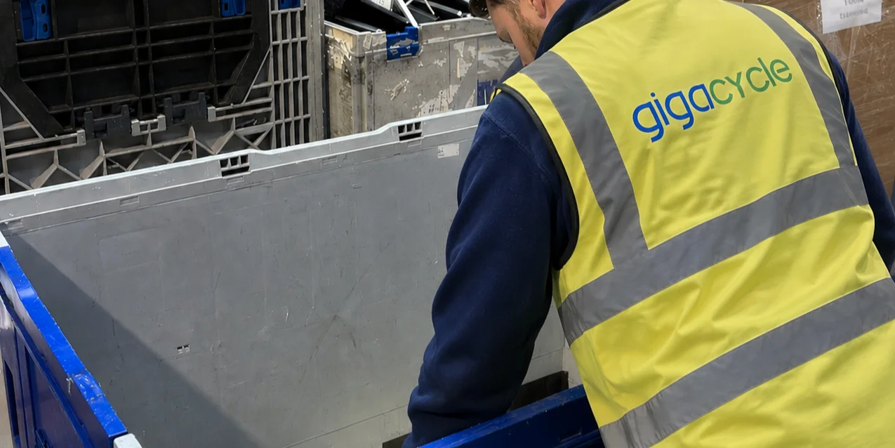 Technician sorting business laptops into refurbishment and recycling piles